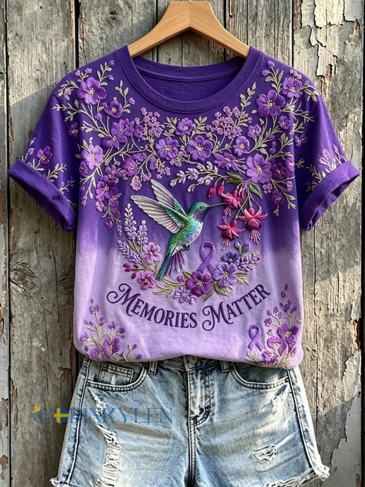 Kvinnors minnen Matter Lila Ribbon Hummingbird Skriv ut kortärmad T-shirt - mörkt / S